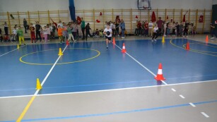 chłopiec biegnący z piłką na sali gimnastycznej