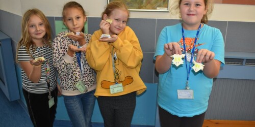 dziewczynki pokazujące żabki zrobione z papieru origami