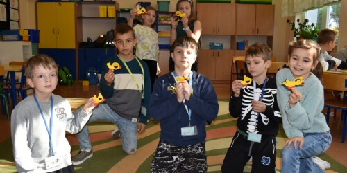 Uczniowie pokazujący kaczki wykonane metodą origami